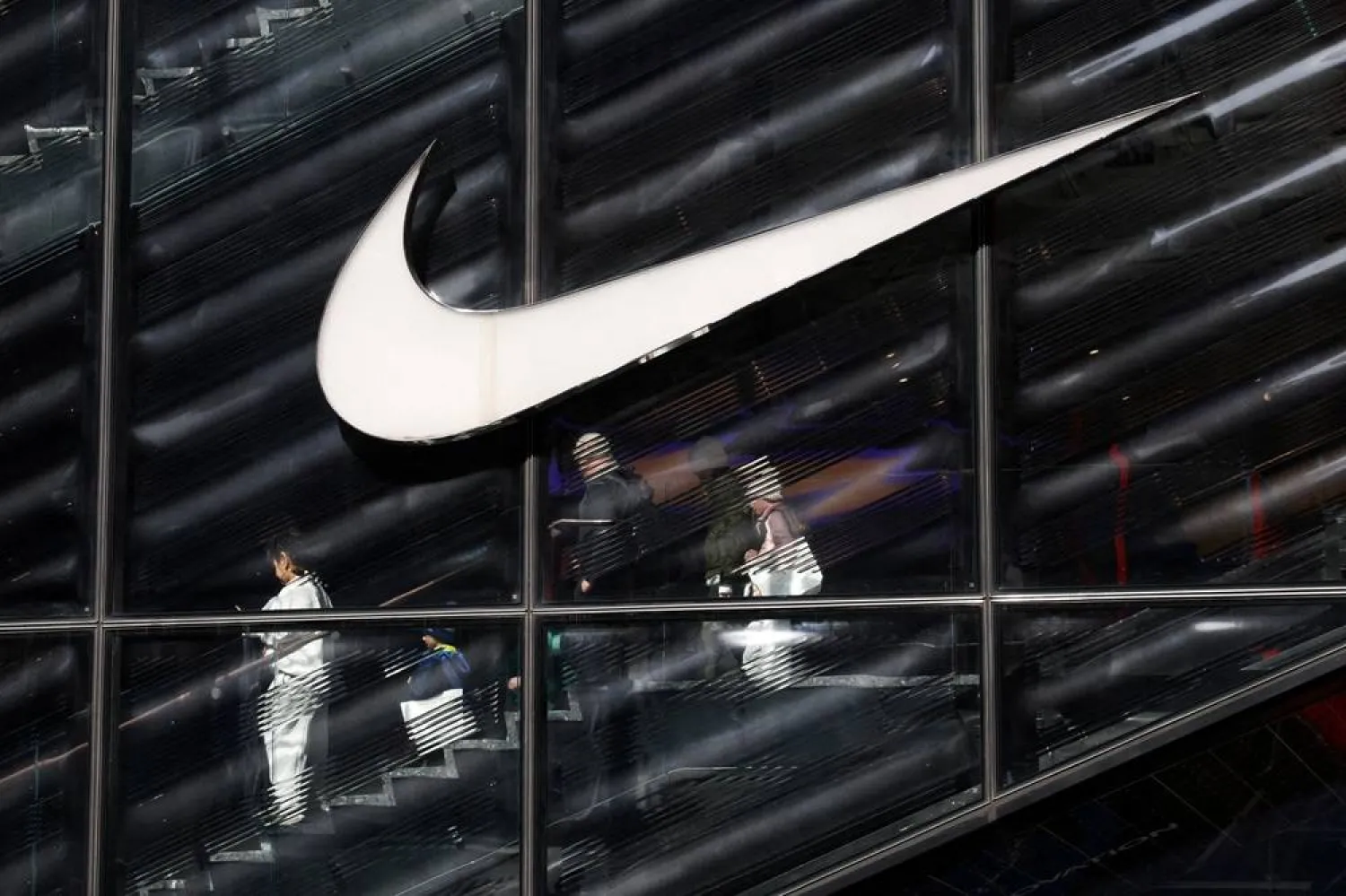 People descend stairs inside a Nike store in New York City, US, April 2, 2025. (Reuters)