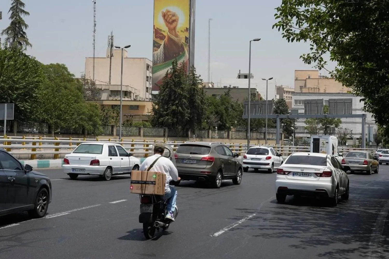  Vehicles drive past a billboard depicting the clenched fist of slain Iranian Supreme Leader Ali Khamenei, in Tehran, Iran, Tuesday, July 21, 2026. (AP)