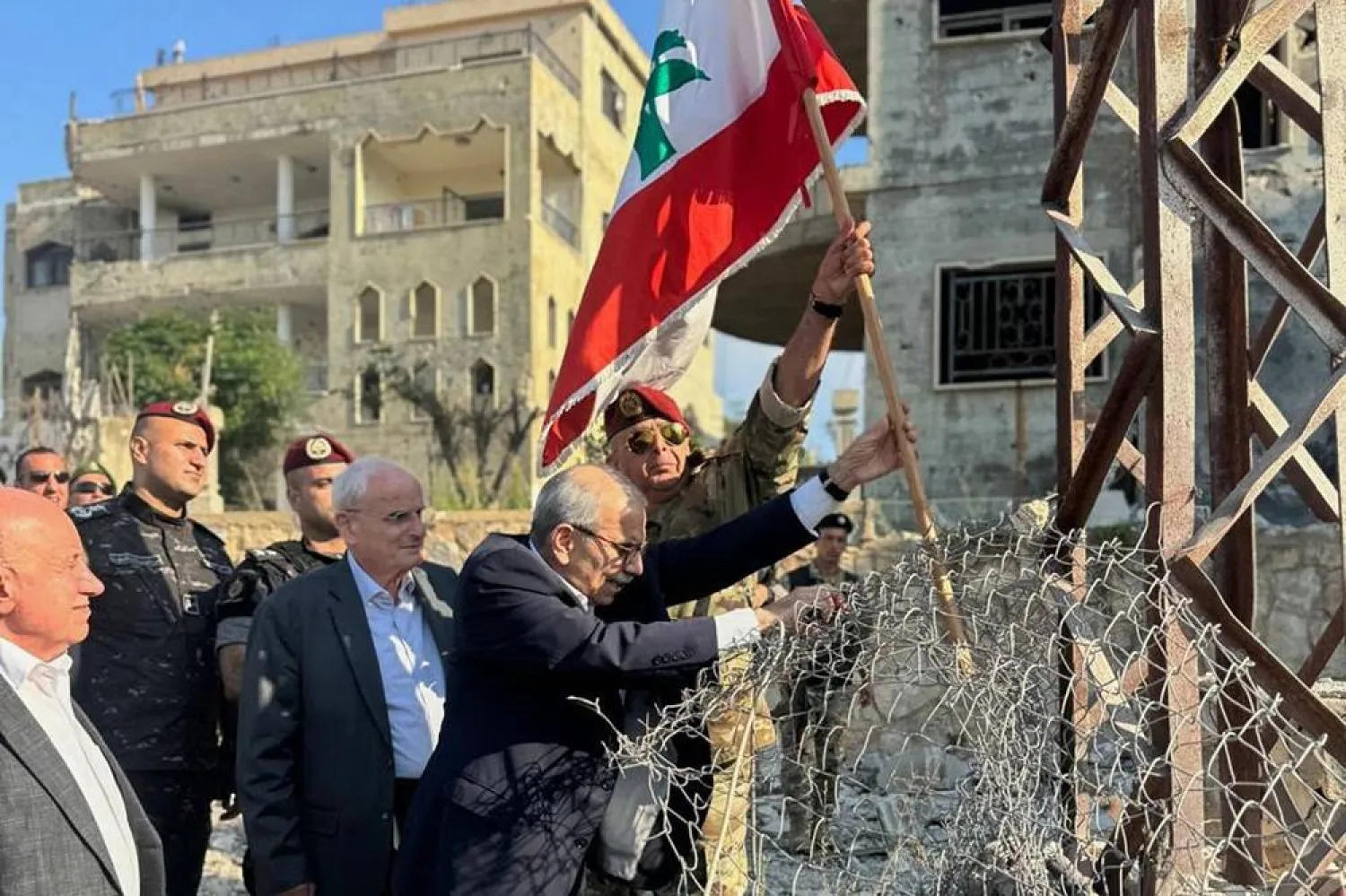 In this photo released by the Lebanese Government press office, Lebanese Prime Minister Nawaf Salam, center, raises a Lebanese flag during a visit to the southern village of Zawtar al-Gharbiya, Lebanon, Wednesday, July 22, 2026. (Lebanese Government press office via AP) 