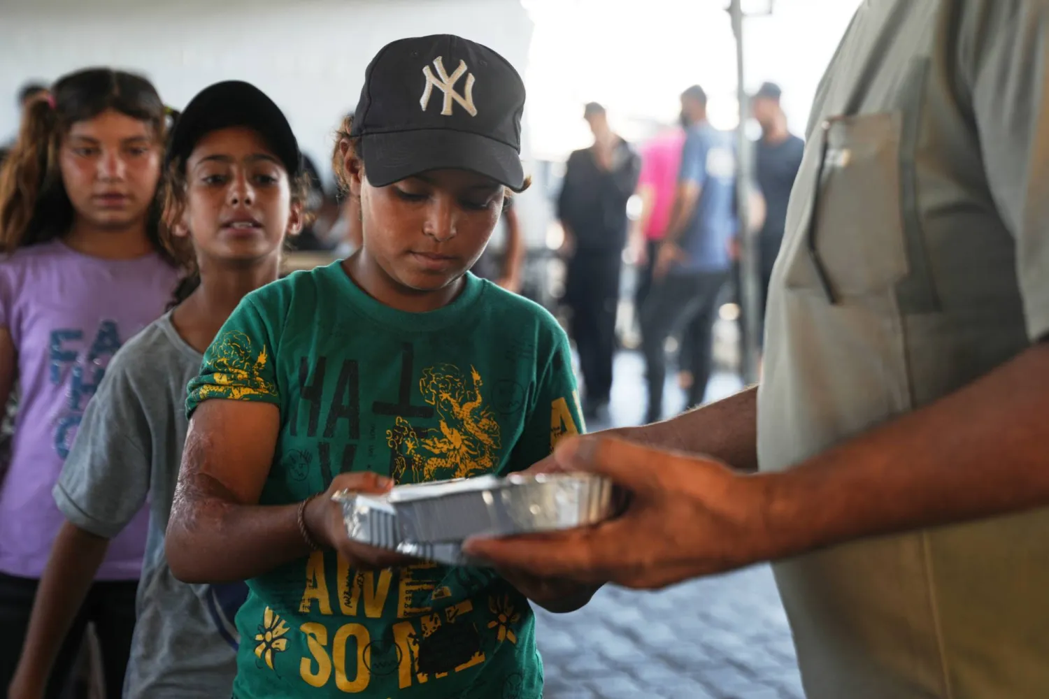 أطفال فلسطينيون نازحون يصطفون لتلقّي الطعام المتبرع به في مطبخ مجتمعي في خان يونس جنوب قطاع غزة 23 يوليو 2026 (أ.ب)