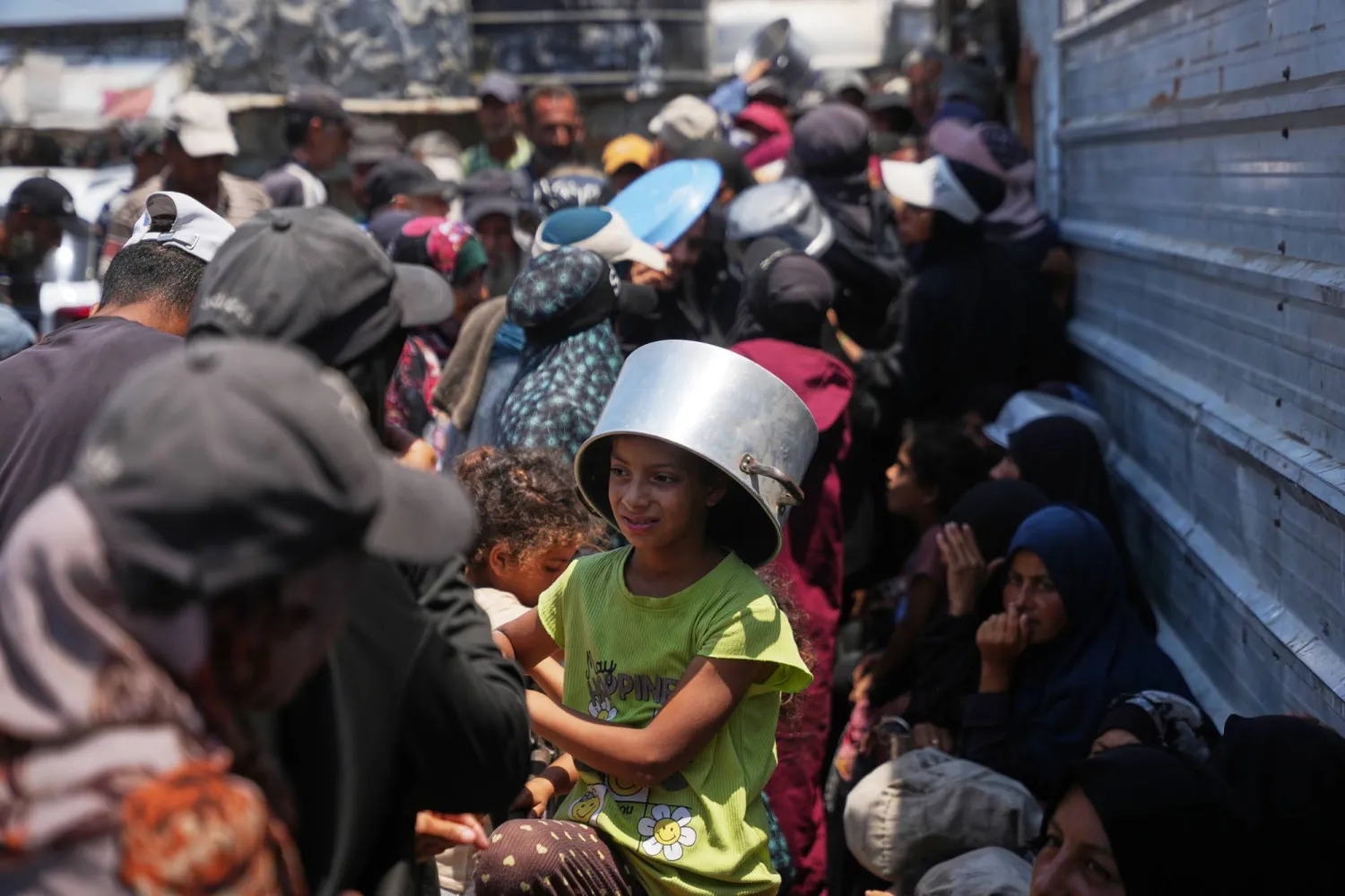 فلسطينيون نازحون يصطفون لتلقّي الطعام المتبرع به في مطبخ مجتمعي بخان يونس جنوب قطاع غزة 23 يوليو الحالي (أ.ب)