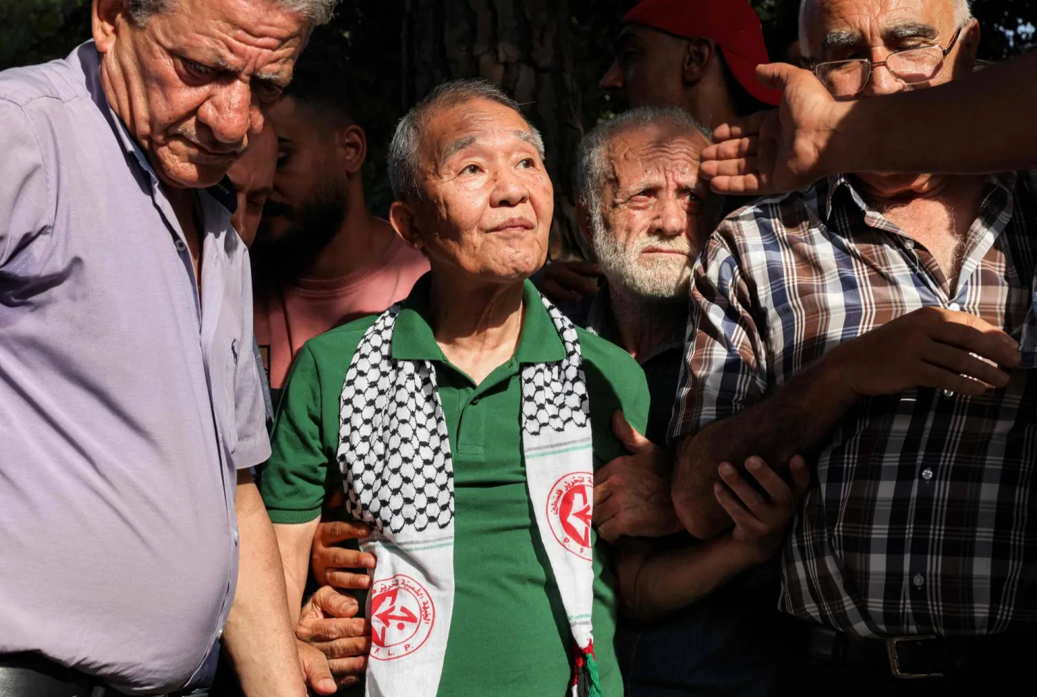 كوزو أوكاموتو (في الوسط) العضو الوحيد الباقي على قيد الحياة من وحدة الكوماندوز المكونة من ثلاثة رجال «الجيش الأحمر الياباني» التي قتلت 26 شخصاً في هجوم على مطار اللد الإسرائيلي يوم 30 مايو 1972 يحضر حفلاً نظّمه مسلحون فلسطينيون لإحياء الذكرى الخمسين لهجوم اللد في إسرائيل... بيروت 30 مايو 2022 (أ.ف.ب)
