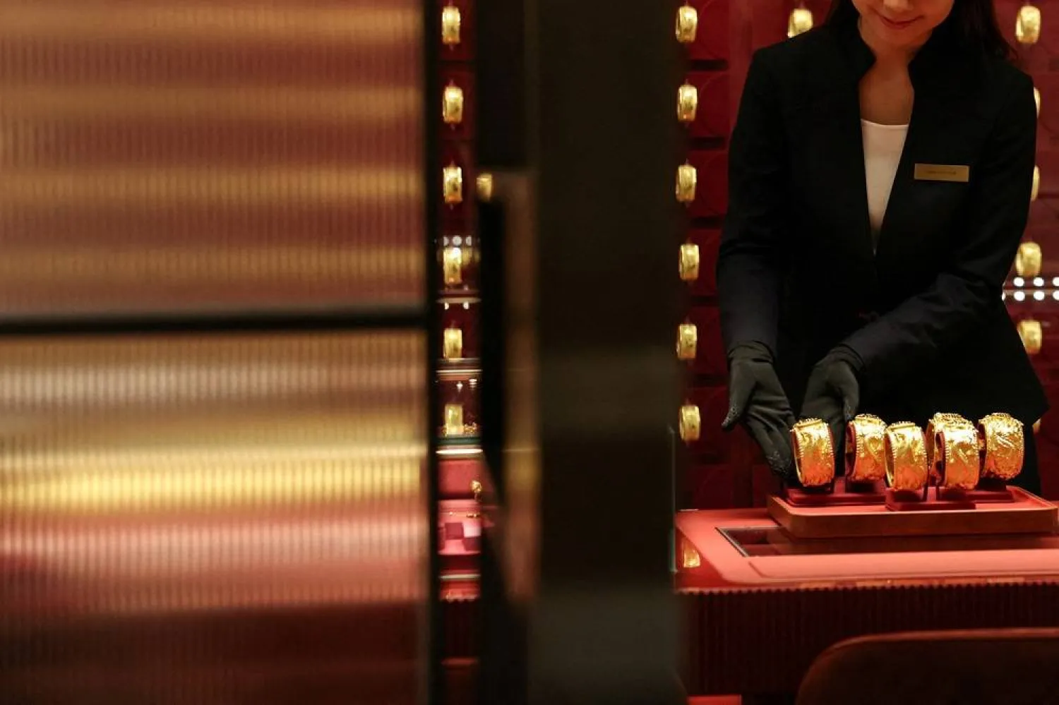 A shop attendant displays pairs of gold bracelets for Chinese weddings during a media preview of the Chow Tai Fook Jewellery Group flagship store soft opening, in Hong Kong, China, February 11, 2026. (Reuters)