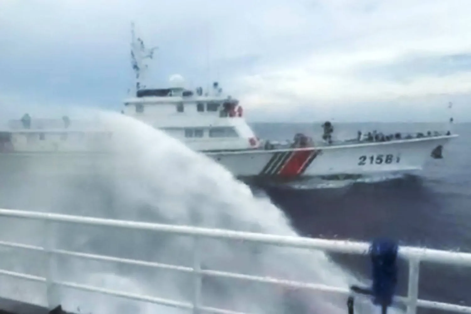 This handout screengrab taken on July 24, 2026 and released by the Philippine Coast Guard (PCG) shows a Chinese Coast Guard ship (back) firing water canon on a Philippine Bureau of Fisheries and Aquatic Resources (BFAR) ship near Scarborough Shoal, in the disputed South China Sea. (Handout / Philippine Coast Guard (PCG) / AFP) 