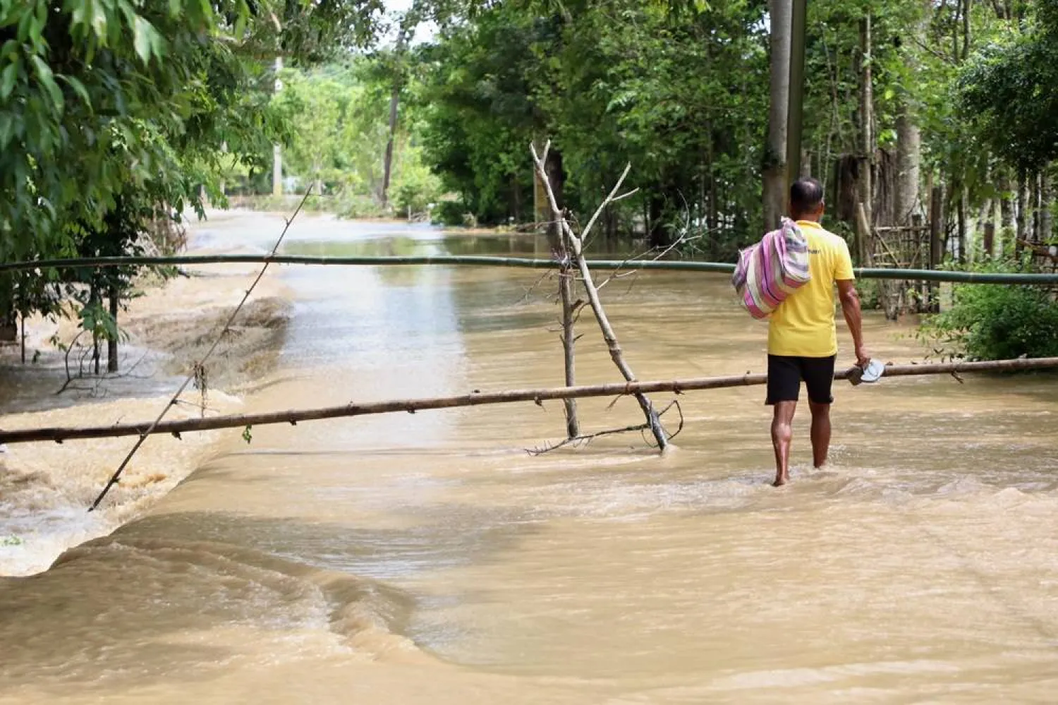 A man wades through the flood water in Teok village in upper Assam, India, Friday, July 24, 2026. (AP) 