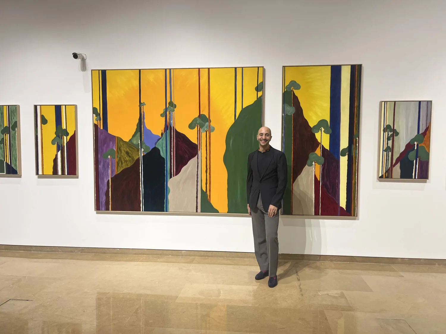 جيلبير الحلبي أمام إحدى لوحاته في معرض «أصداء الوجود» (الجهة المنظّمة)