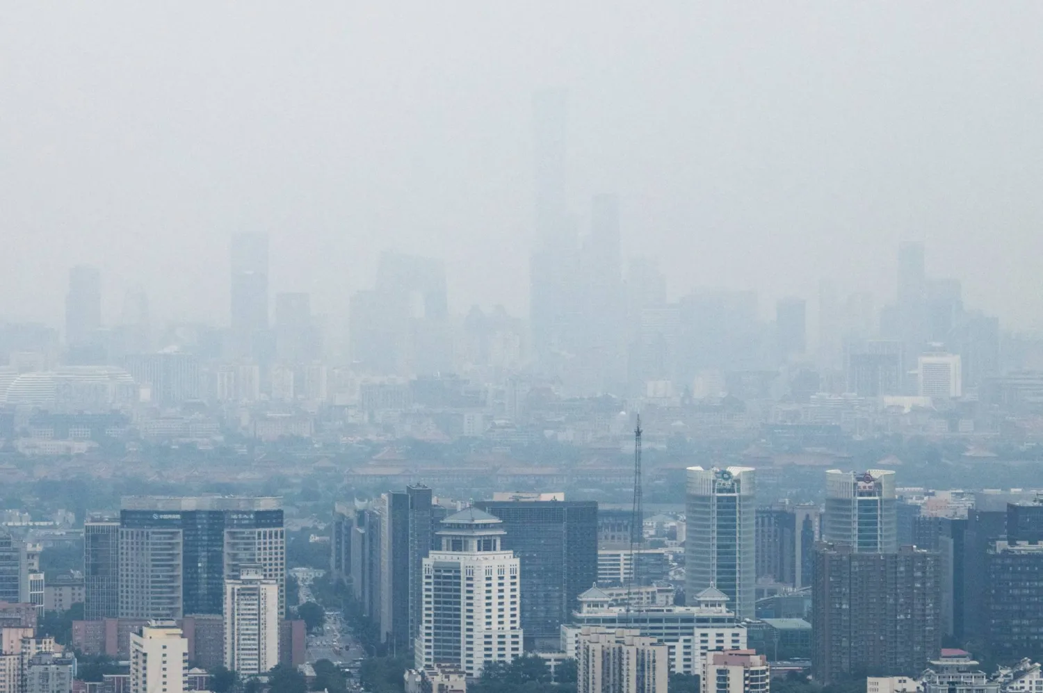 Skyscrapers in Beijing's Central Business District (CBD) and the Forbidden City are seen through haze in Beijing, China, July 24, 2026. REUTERS/Maxim Shemetov