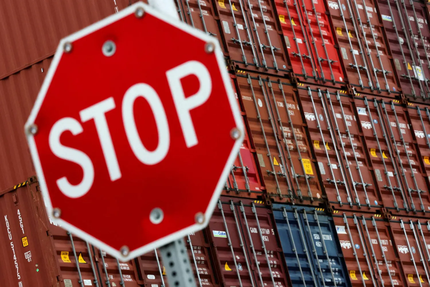 تظهر إشارة «توقف» أمام حاويات شحن في ميناء لونغ بيتش في لونغ بيتش بكاليفورنيا (رويترز)