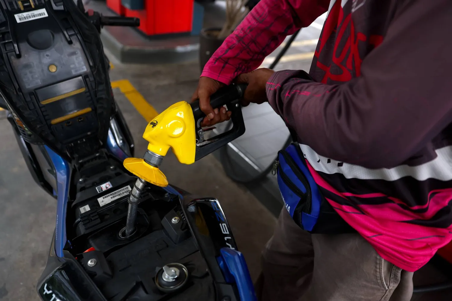 A man refuels his motorbike at the petrol station in Kuala Lumpur, Malaysia, 24 July 2026. (EPA) 
