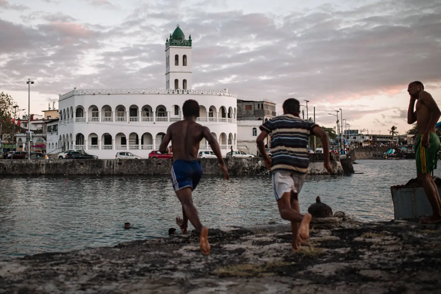  Children jump in the ocean in the former dhow port of Kalaweni, opposite the Grand Mosque, in Moroni's historic Medina on July 17, 2026. (AFP) 