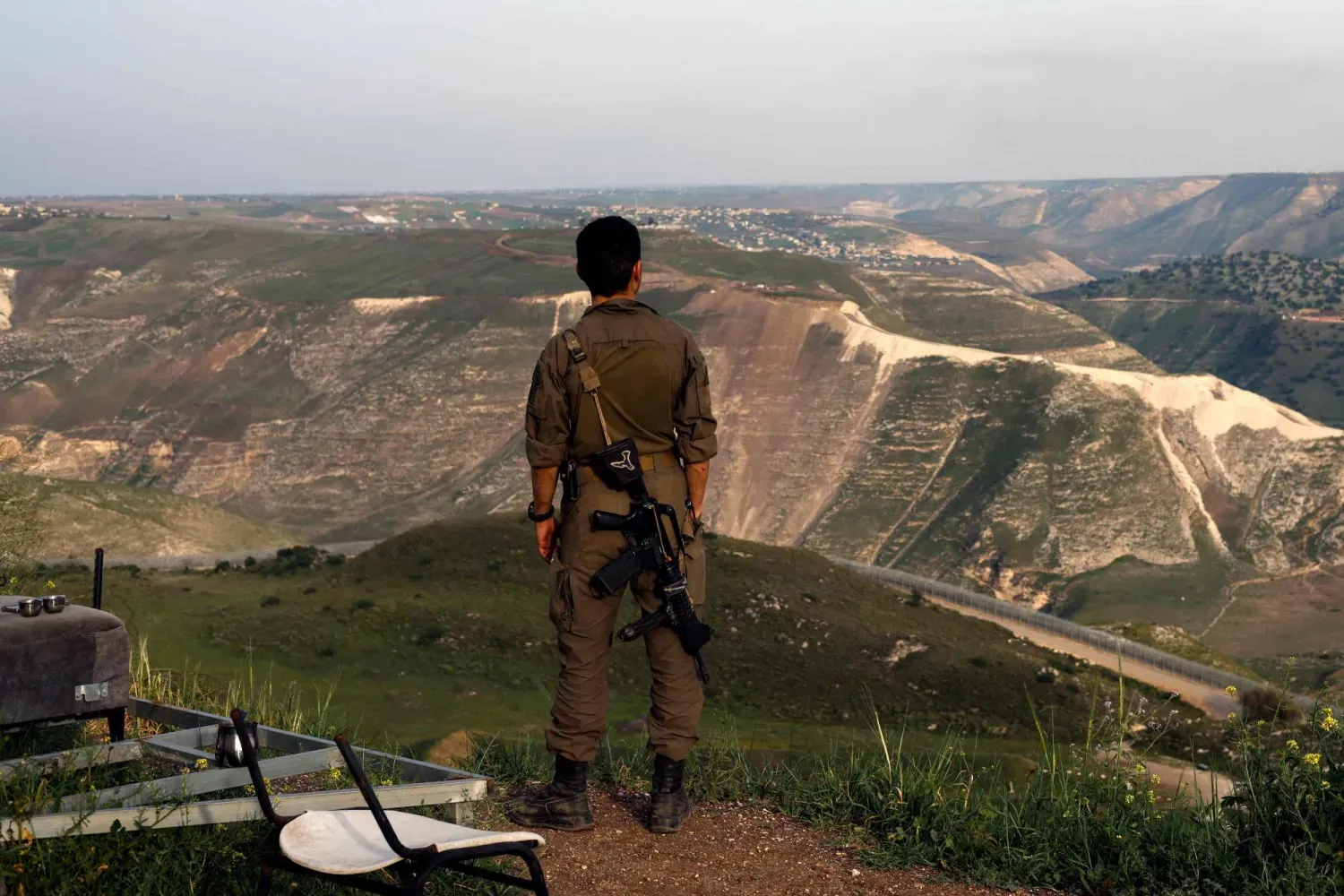 İşgal altındaki Golan Tepeleri’nde, Suriye’nin güneyine bakan bir gözetleme noktasında duran İsrail askeri... 25 Mart 2025 (Arşiv – AFP)