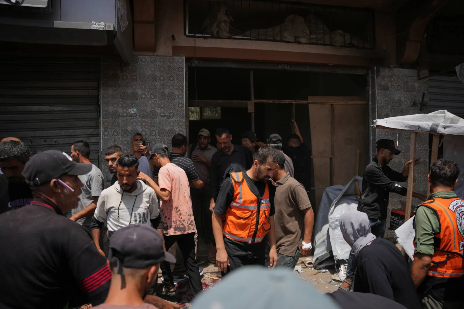 فلسطينيون يتفقدون موقع غارة عسكرية إسرائيلية في دير البلح، وسط قطاع غزة (أ.ب)