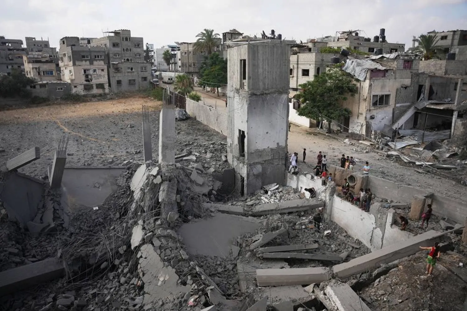Palestinians inspect a destroyed building at the site of an Israeli airstrike, at al-Bureij refugee camp, central Gaza Strip, Friday, July 24, 2026. (AP)