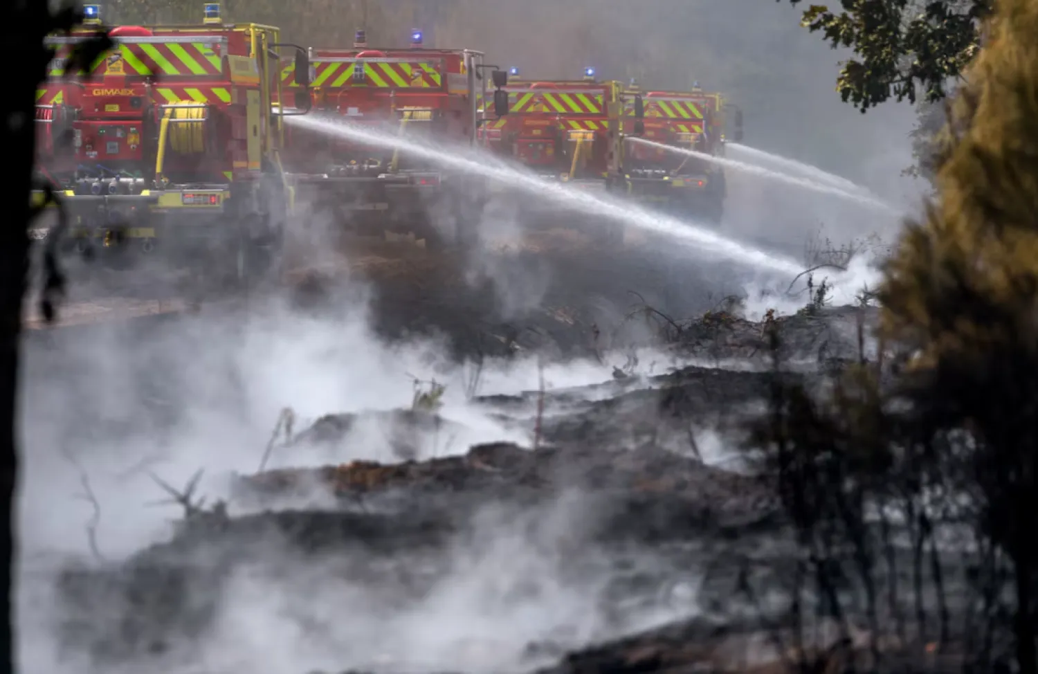Firefighters work to battle wildfires amid drought conditions following a heatwave and water shortages across much of France, in Marcheprime, Gironde department, France, July 27, 2026. REUTERS
