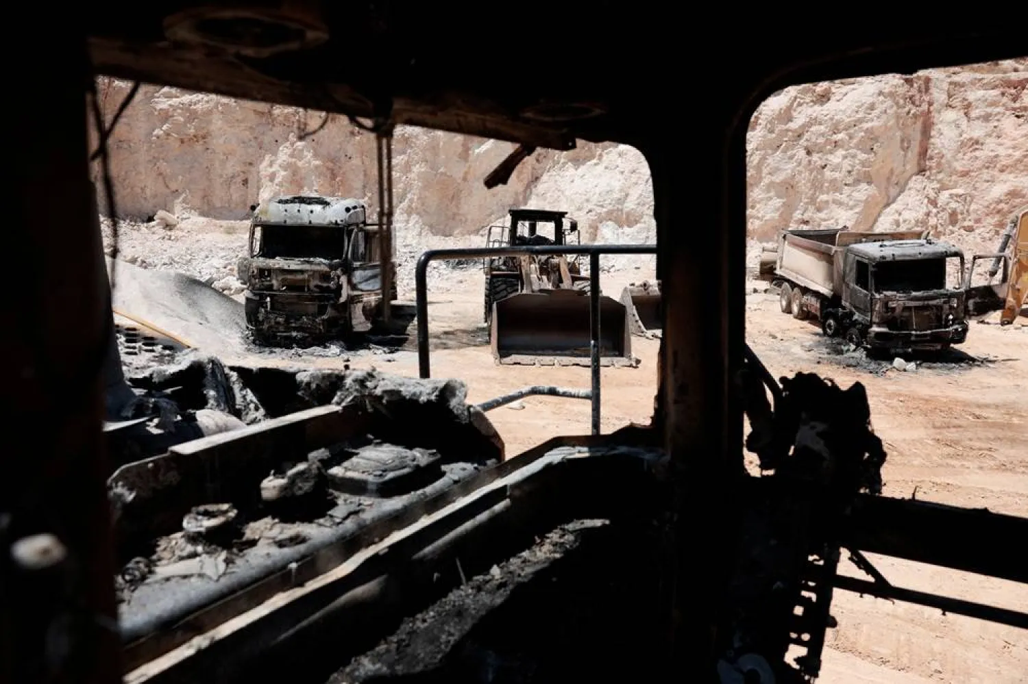 Heavy machinery that was burned inside a Palestinian quarry after Palestinians say Israeli settlers attacked yesterday, near Ramallah, in the Israeli-occupied West Bank, July 27, 2026. (Reuters)
