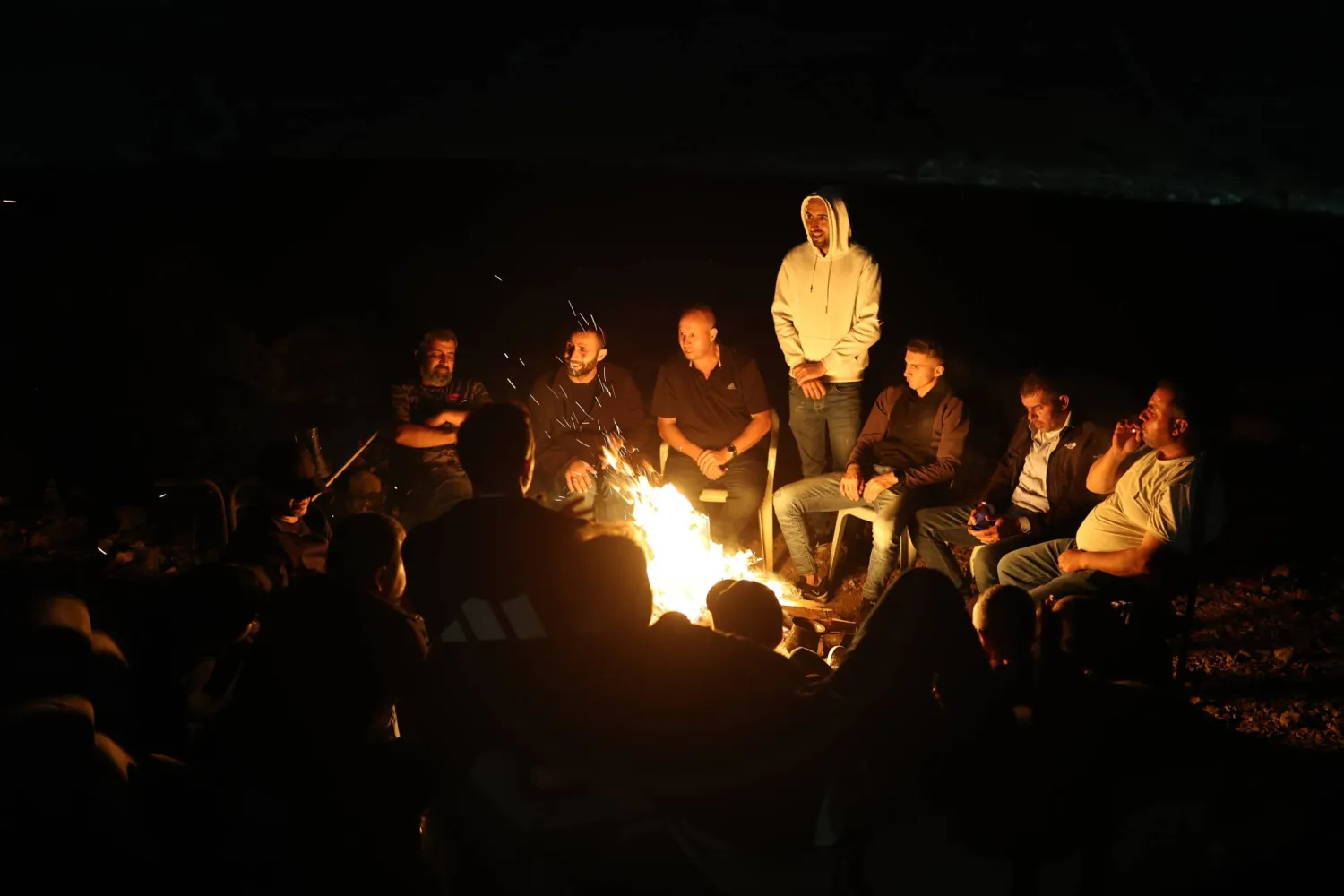 فلسطينيون من قرية سنجل في الضفة الغربية خلال نوبة حراسة ليلية لمنع هجمات المستوطنين الإسرائيليين (إ.ب.أ)