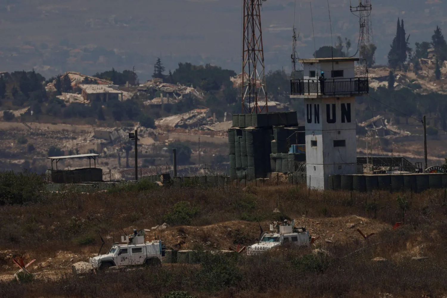 This picture, taken from a position in northern Israel, near the border with Lebanon, shows United Nations Interim Force in Lebanon (UNIFIL) armored vehicles driving past destroyed buildings in southern Lebanon on July 22, 2026. (AFP)