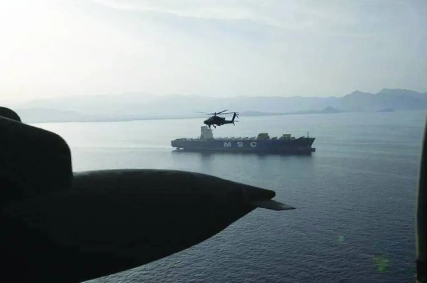 Cuma günü Hürmüz Boğazı üzerinde uçan ABD'ye ait AH-64 model bir Apache helikopteri (CENTCOM)