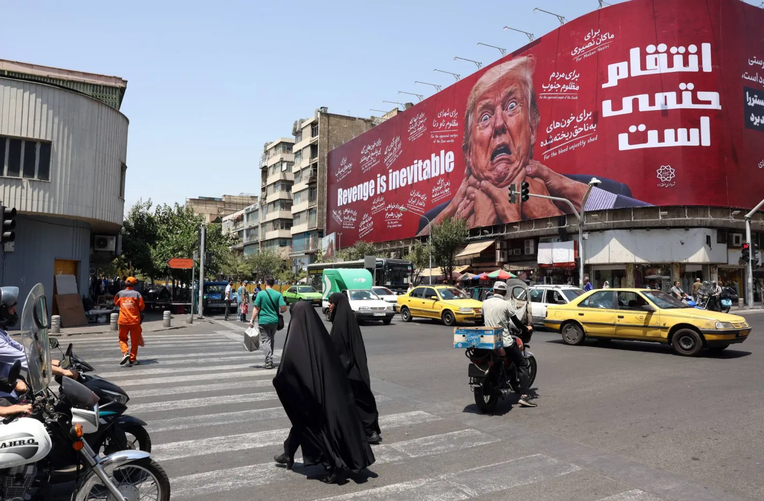 Women walk past an anti-US and Trump billboard in a street in Tehran, Iran, 27 July 2026. EPA/ABEDIN TAHERKENAREH