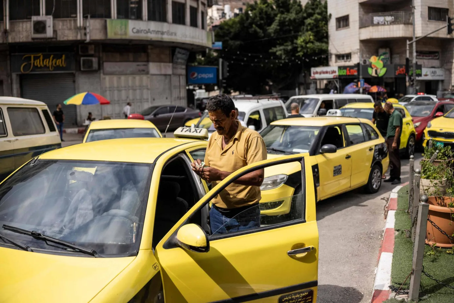 A Palestinian taxi driver waits in a long queue outside a petrol station during a fuel crisis in Nablus, in the Israeli-occupied West Bank on July 26, 2026. (AFP)