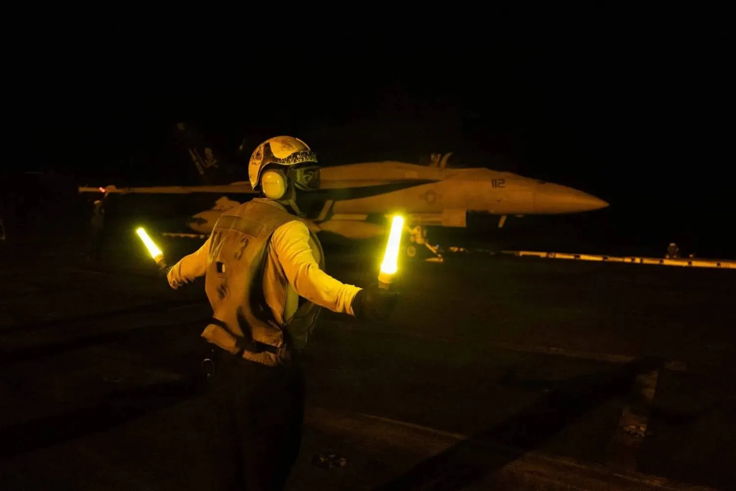 A US sailor signals an F/A-18E Super Hornet on the flight deck of Nimitz-class aircraft carrier USS George H W Bush on July 21, 2026. - AFP
