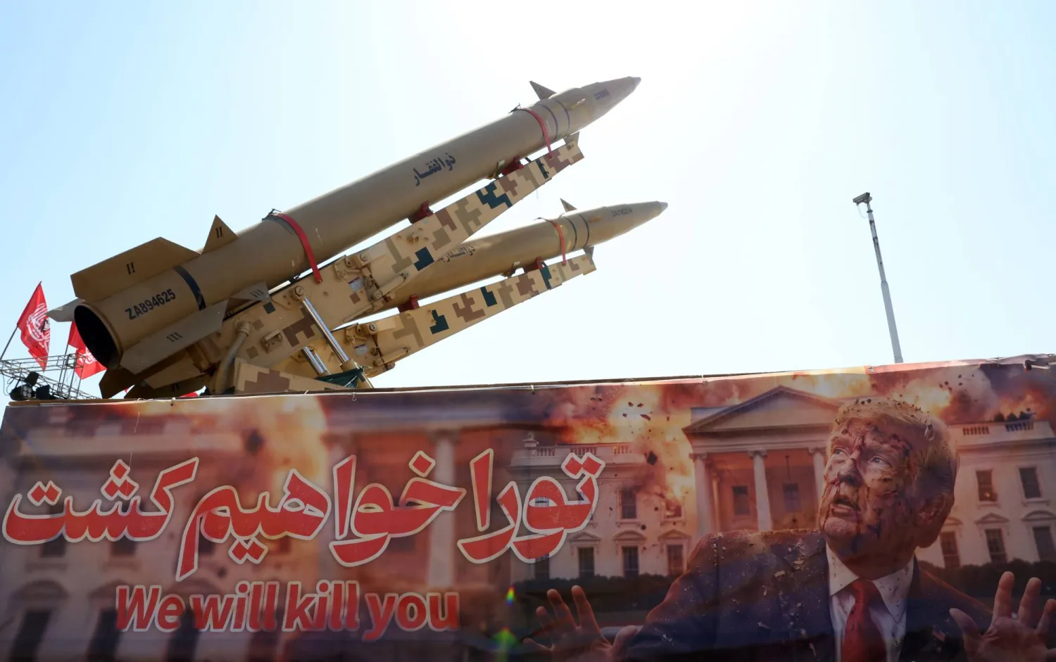 صواريخ «ذو الفقار» الإيرانية معروضة فوق لافتة تتوعد بقتل الرئيس الأميركي دونالد ترمب في ساحة آزادي بطهران الخميس (إ.ب.أ)