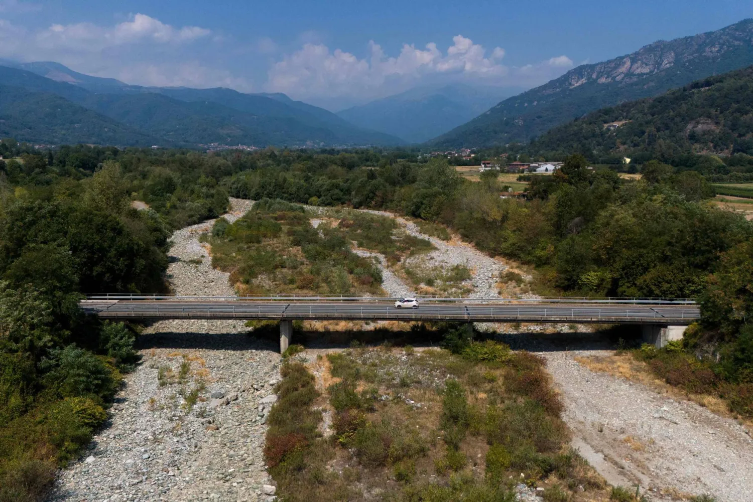 This aerial view shows a car crossing the bridge over the Po River in Martiniana Po, on July 30, 2026. (AFP)