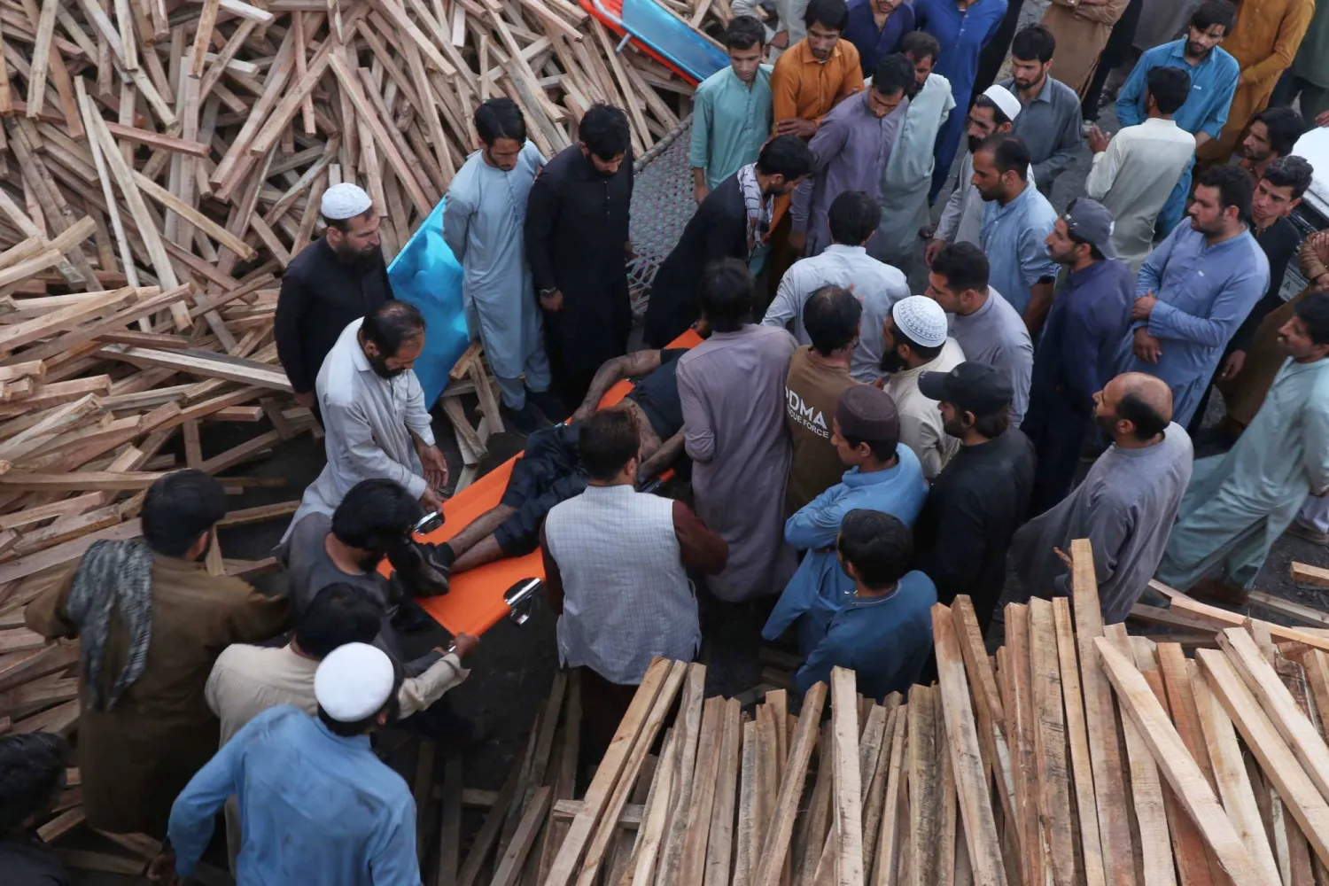 سكان محليون ينقلون جثة أحد القتلى جراء الانفجار في المنجم (أ.ب)