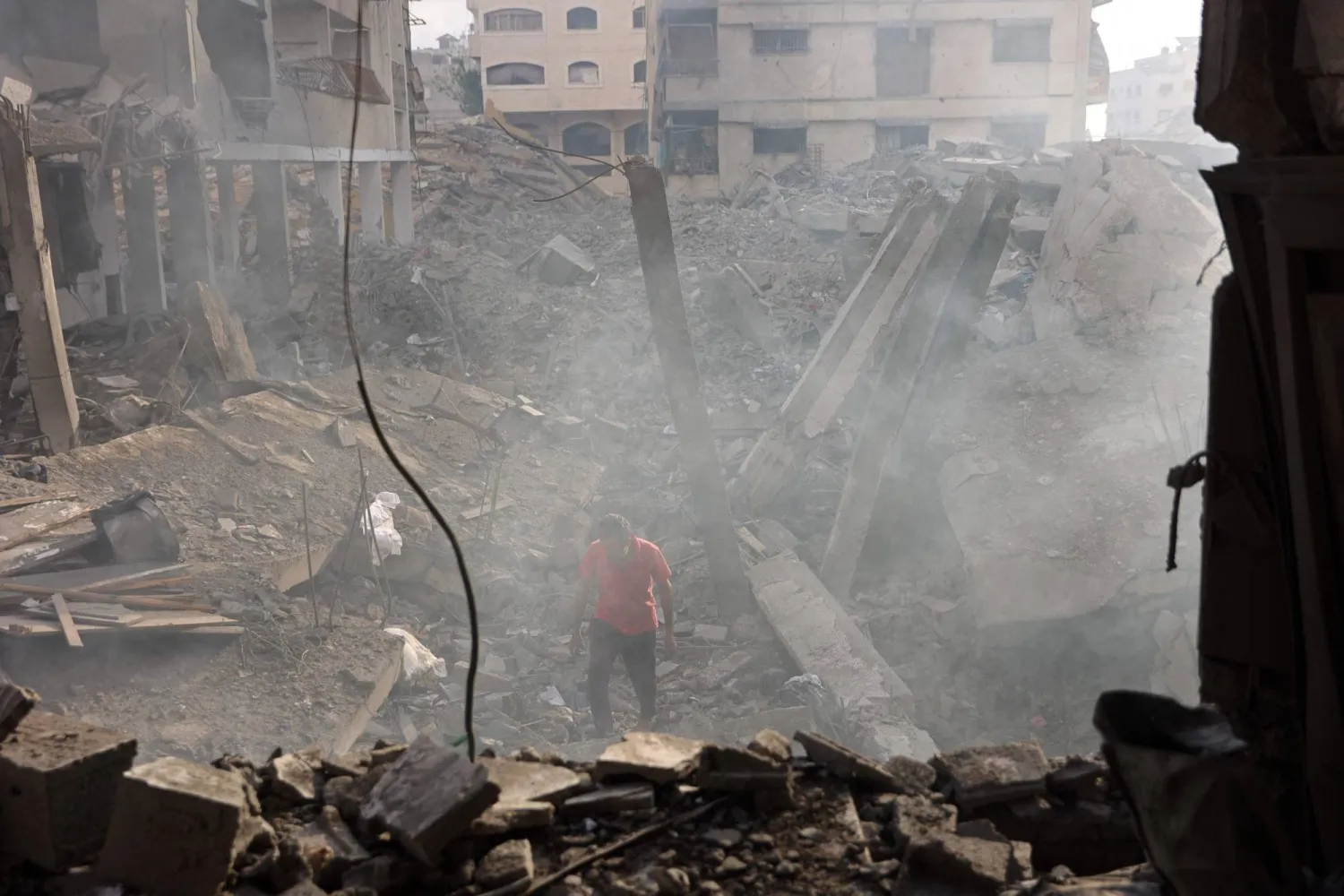 A Palestinian man looks for his belongings amid the debris of a destroyed building following an Israeli strike at the Al-Jalaa street in Gaza City on July 24, 2026. (AFP)