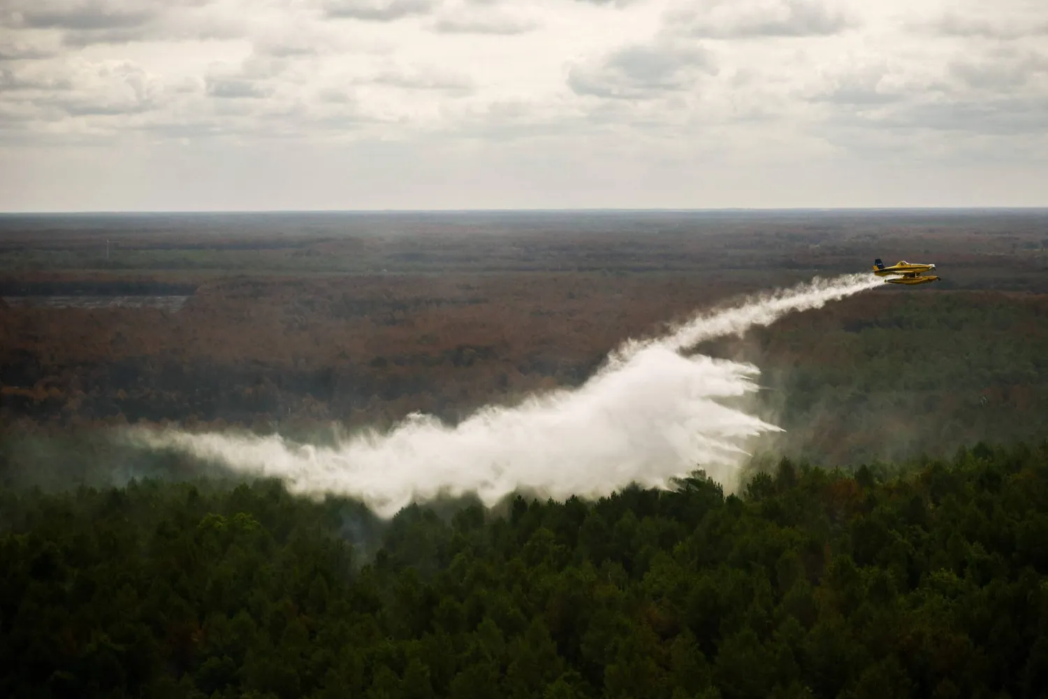 This aerial photograph taken from a French Civil Security rescue coordination helicopter shows a Turkish Air Tractor AT-802F Fire Boss amphibious water bomber A-172 dropping a load of water over a wildfire in Le Porge, south-western France on July 31, 2026, as a wildfire has been ravaging the forest north of the Arcachon Basin (Gironde) since July 22. (AFP)