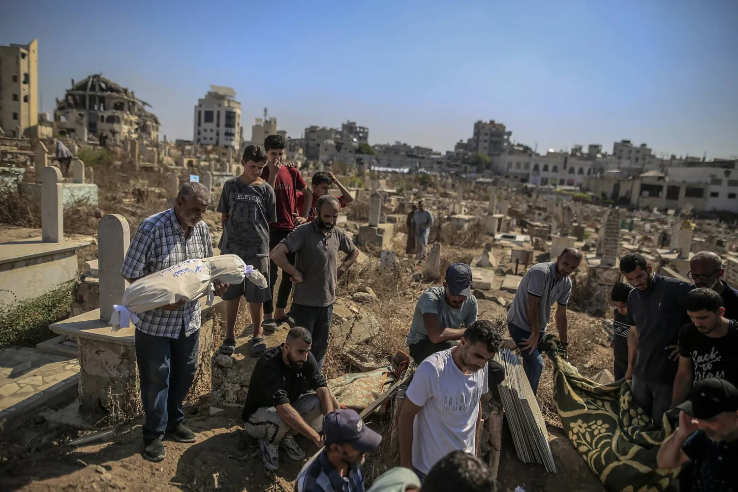  Palestinian relatives of the Al-Masri family conduct their burial ceremony at a cemetery, in Gaza City, Gaza Strip, 21 July 2026. Firas Al-Masri, his wife, Salsabil, and their four children were killed in Gaza City, when the Israeli army targeted their home with a drone early 21 July, according to the Gaza Ministry of Health.  EPA/MOHAMMED SABER