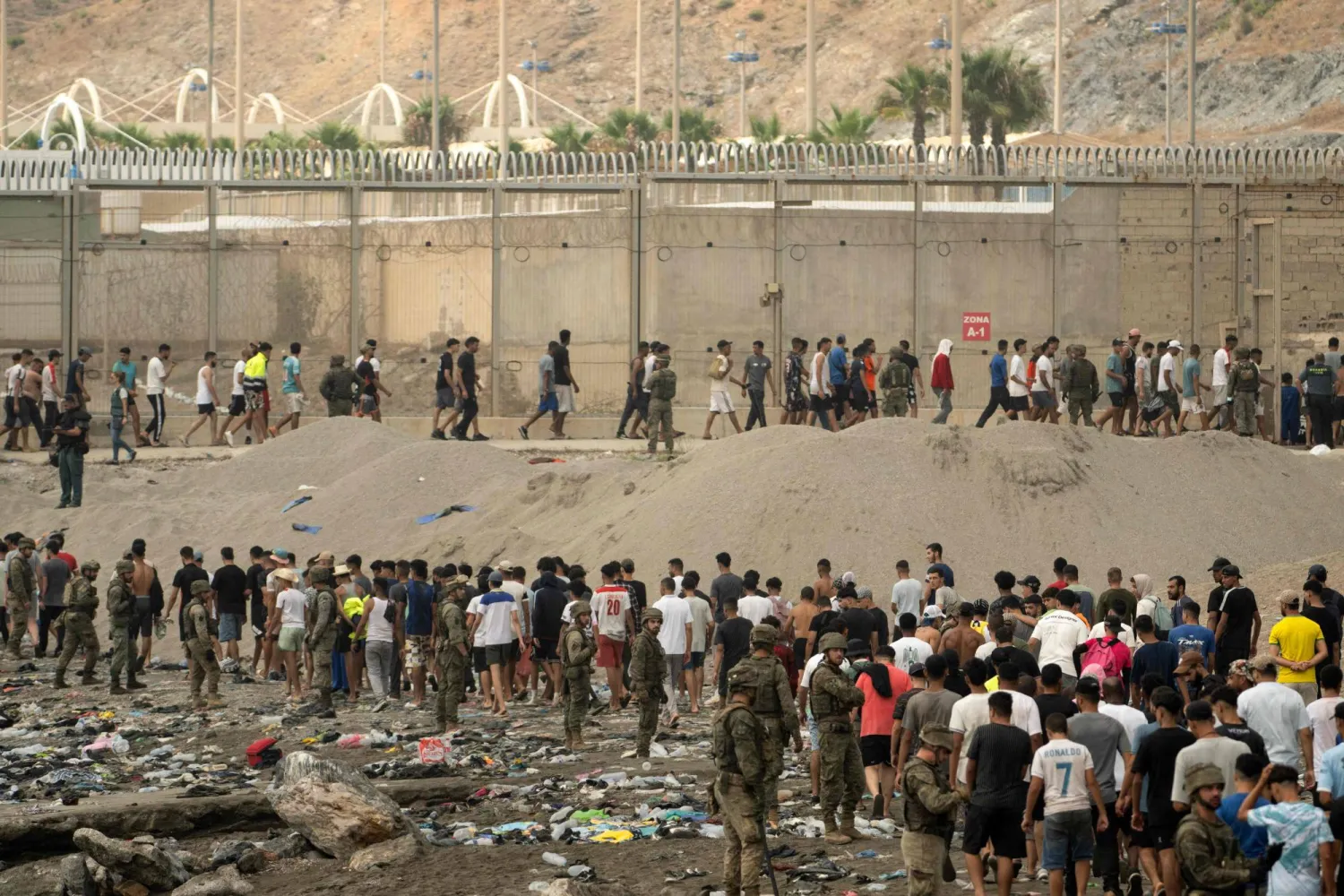 عناصر الشرطة الإسبانية في جيب سبتة تنظِّم عودة مئات المهاجرين إلى المغرب (أ.ف.ب)