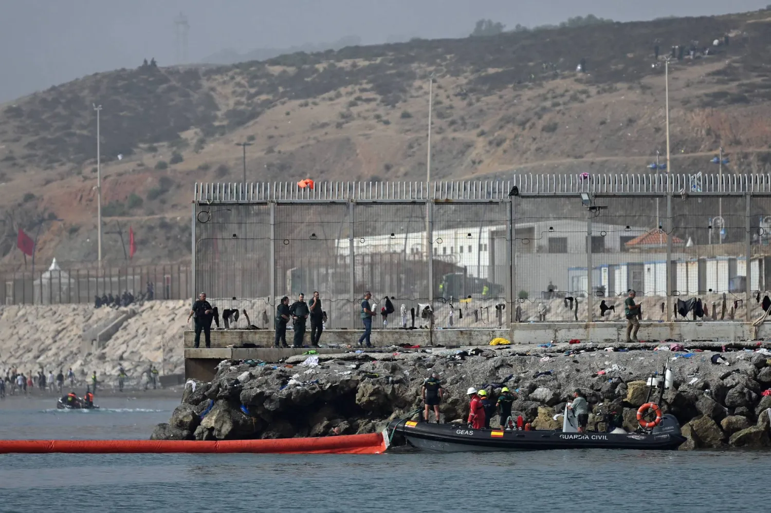 A 500-meter-long pneumatic barrier is deployed in the water by a Spanish Guardia Civil boat near the border post to reinforce security following illegal crossings from Morocco into the Spanish enclave of Ceuta, on August 1, 2026. (Photo by JORGE GUERRERO / AFP)