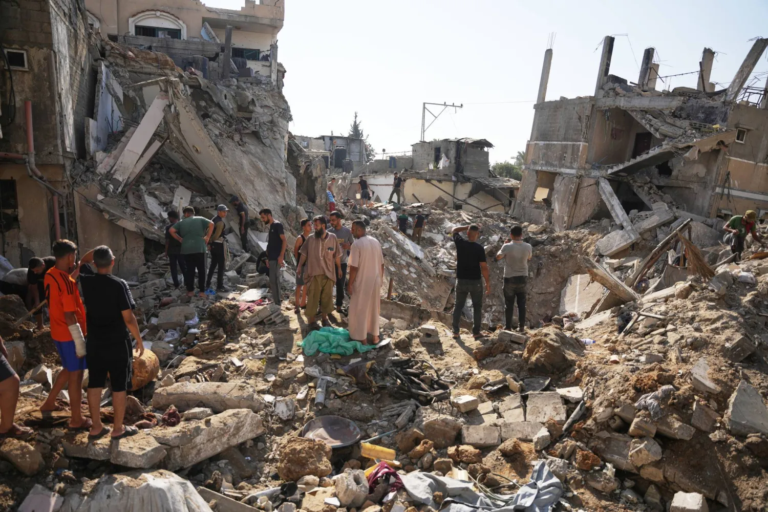 Palestinians inspect destroyed buildings at the scene of an Israeli airstrike, at al-Maghazi refugee camp, central Gaza Strip, Saturday, Aug. 1, 2026. (AP Photo/Abdel Kareem Hana)