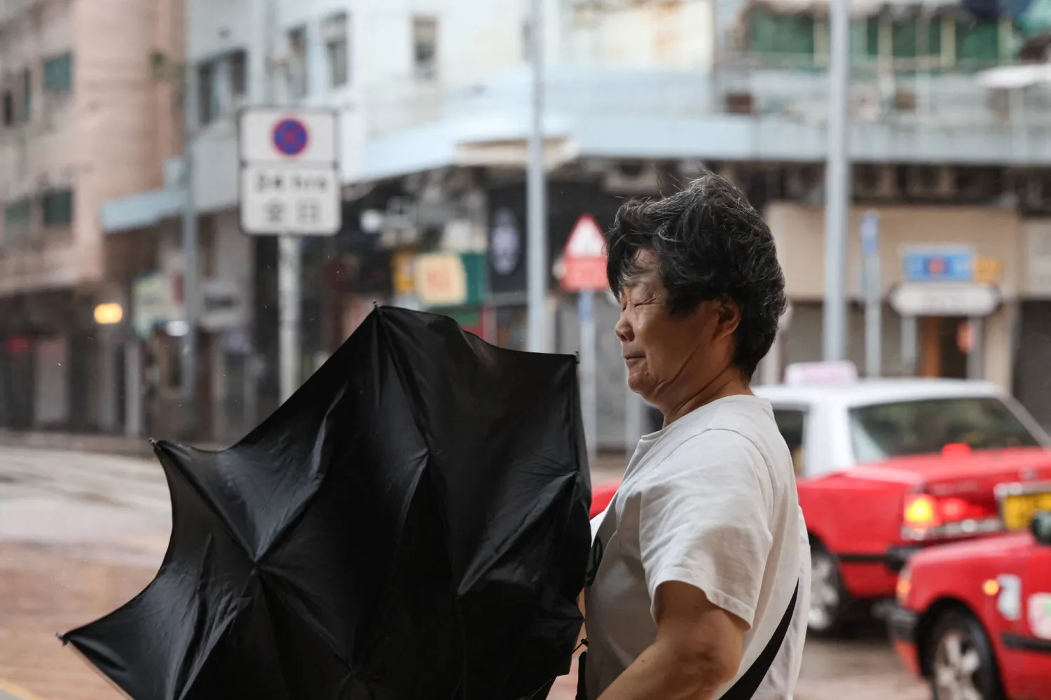  A pedestrian holds an inverted umbrella against strong winds during heavy rain from Typhoon Noul, in Hong Kong, China, July 26, 2026. (Reuters)