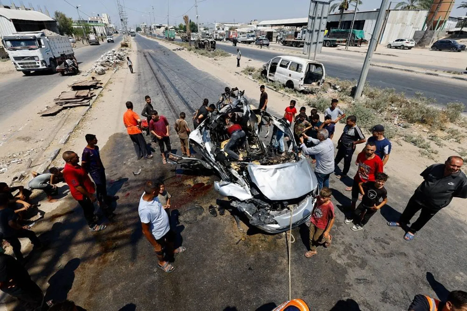  Palestinians inspect the site of an Israeli strike on a vehicle, according to medics, in Deir al-Balah in the central Gaza Strip, August 2, 2026. (Reuters)