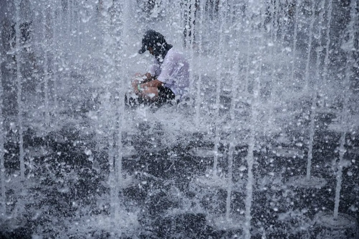 A boy cools down at a ground fountain during a heatwave warning in Seoul, South Korea, August 3, 2026. (Reuters)