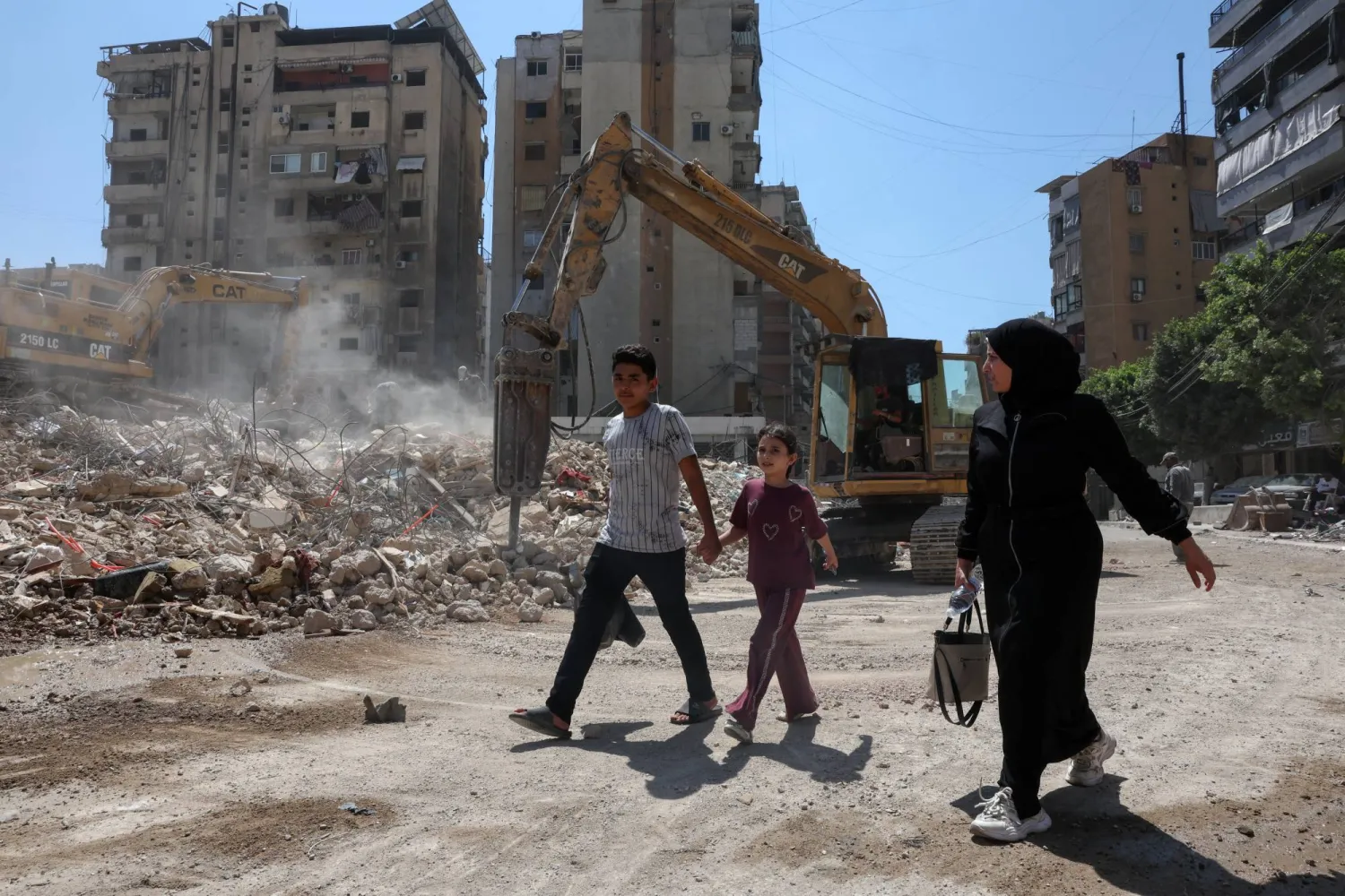 People walk past the rubble of buildings damaged in Israeli strikes in Beirut’s southern suburbs, following a ceasefire agreement between Lebanon and Israel, in Beirut, Lebanon, July 6, 2026. REUTERS/Mohamed Azakir