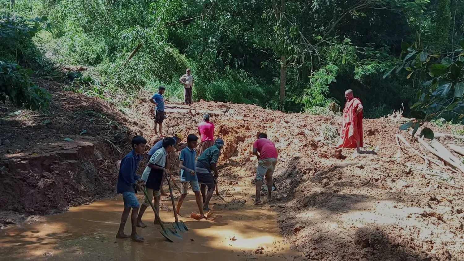 People clean a stretch of a road covered with mud following heavy rain in Nawalapitiya, Sri Lanka, Tuesday, Aug. 4, 2026. (AP Photo)