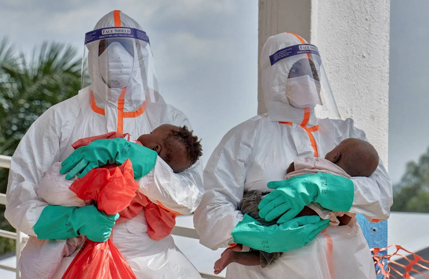 FILE PHOTO: Congolese medical workers dressed in personal protective equipment (PPE) carry children tested and cleared off from Ebola from Saint Nicholas orphanage, at the Centre Medical Evangelique (CME) within the secured Ebola response zone, in Hoho commune of Bunia town, Ituri province, Democratic Republic of Congo, June 9, 2026. REUTERS/Gradel Muyisa Mumbere/File Photo