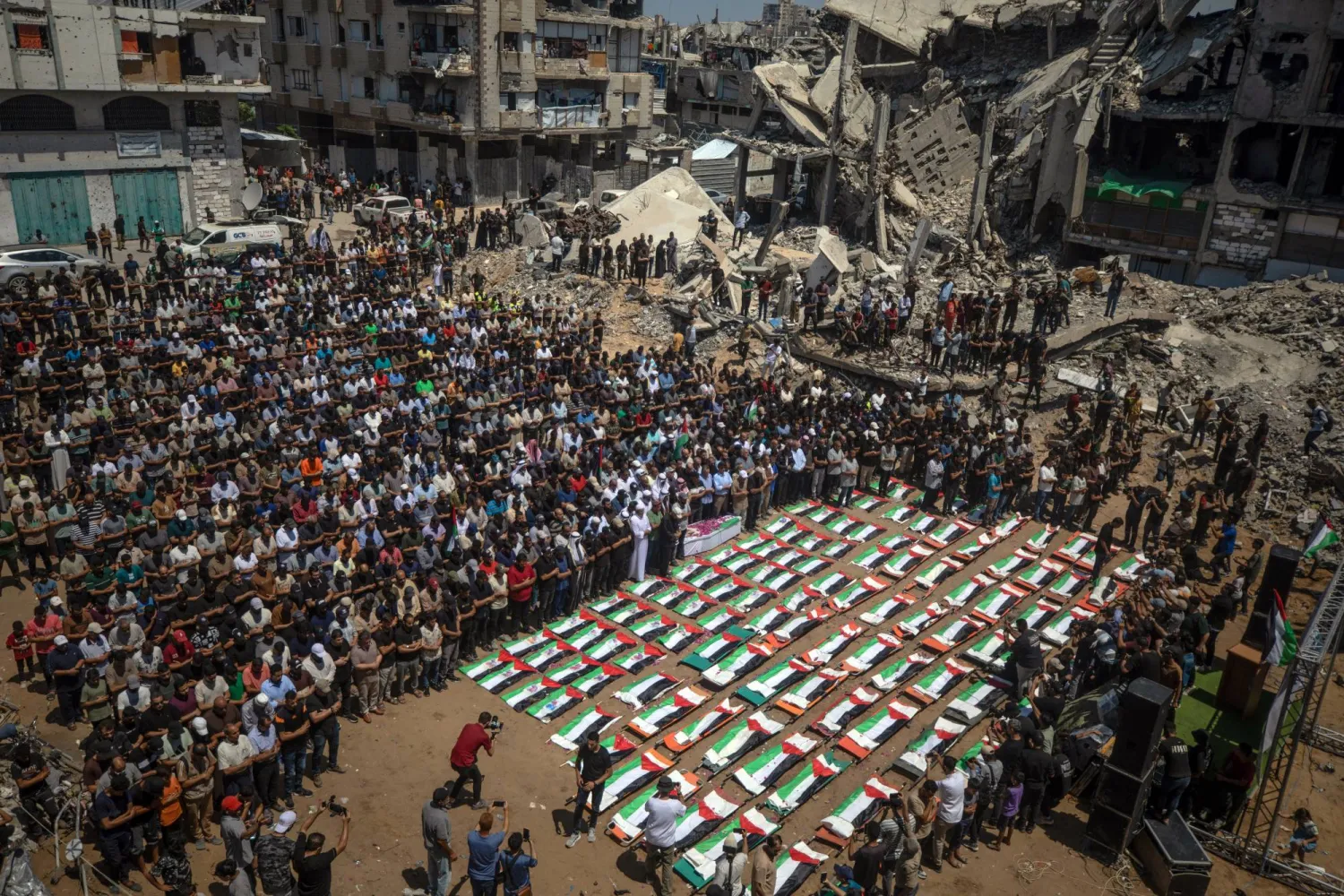 فلسطينيون يشيعون جثامين 112 شخصاً من عشيرة واحدة بشرق مدينة غزة يوم الثلاثاء (إ.ب.أ)