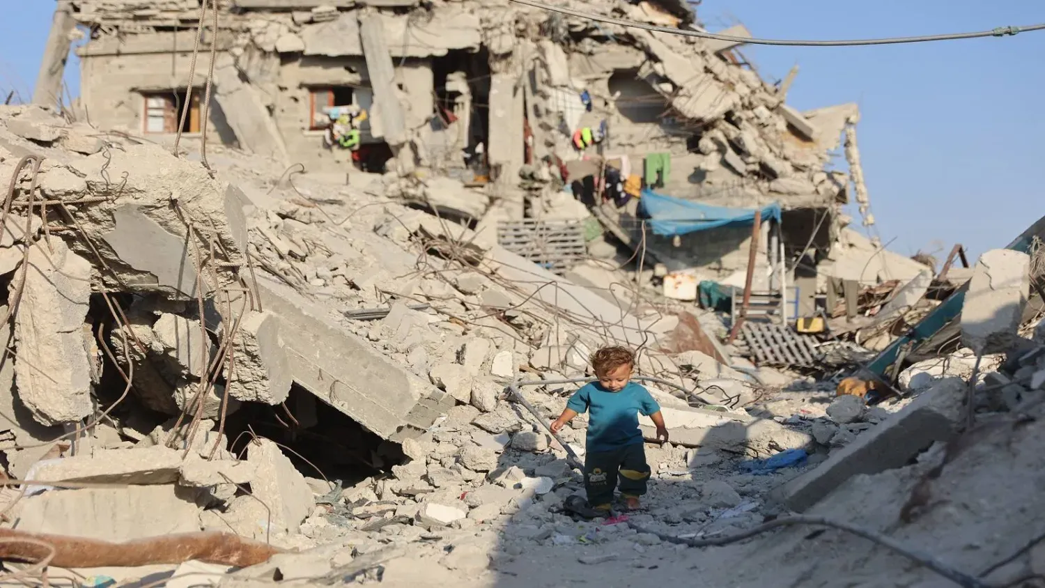 Gazze Şeridi'nin kuzeyindeki Cibaliye mülteci kampında, yıkılan binaların enkazı arasında bir çocuk, (AFP)