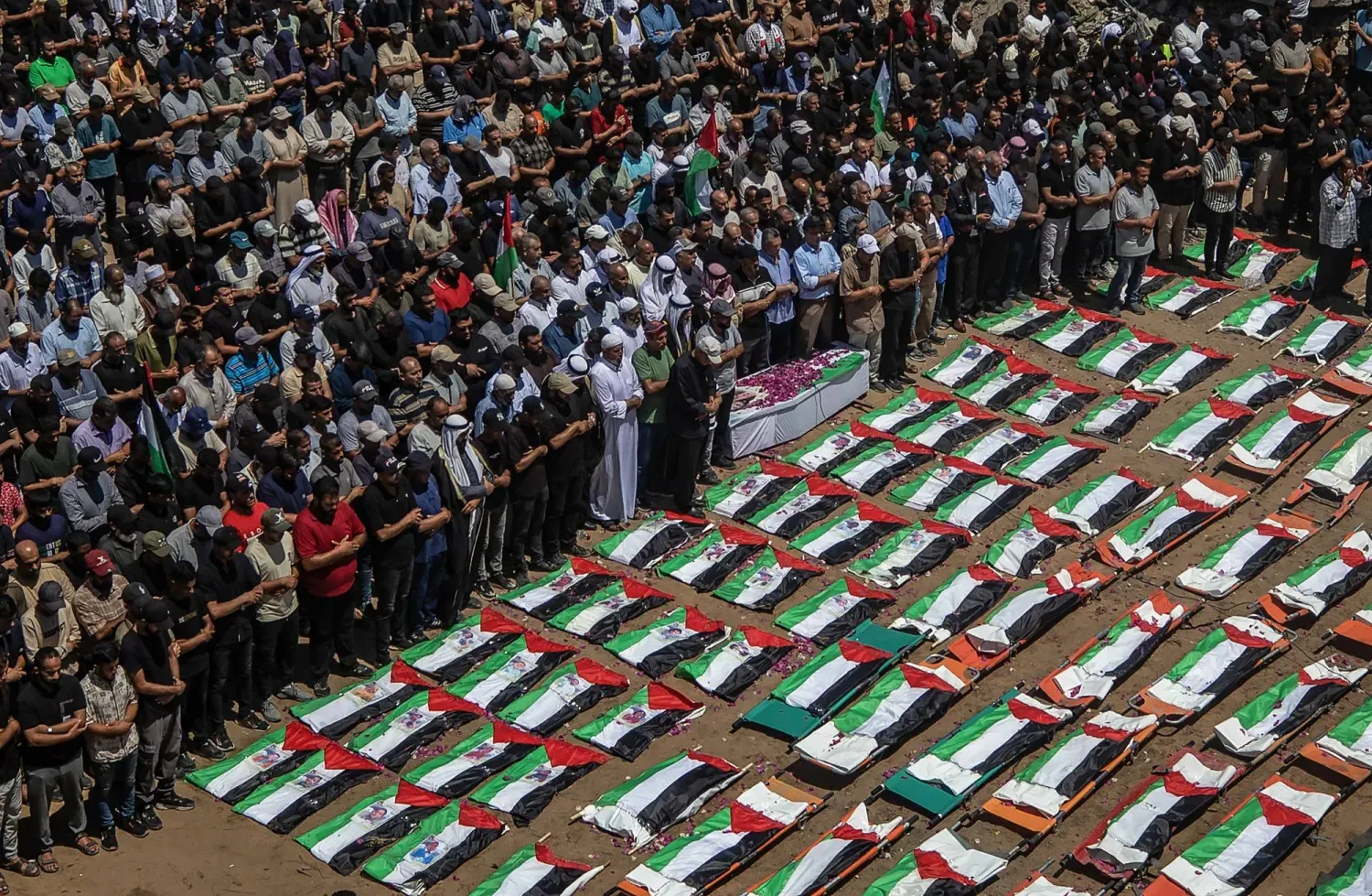 Dün Gazze'de yıkılan evlerin enkazından çıkarılan tek bir aşirete mensup 112 kişinin cenaze törenine katılan Filistinliler (AFP)
