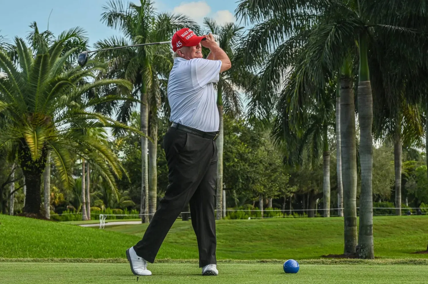 Trump en sevdiği spor olan golf oynarken (AFP)