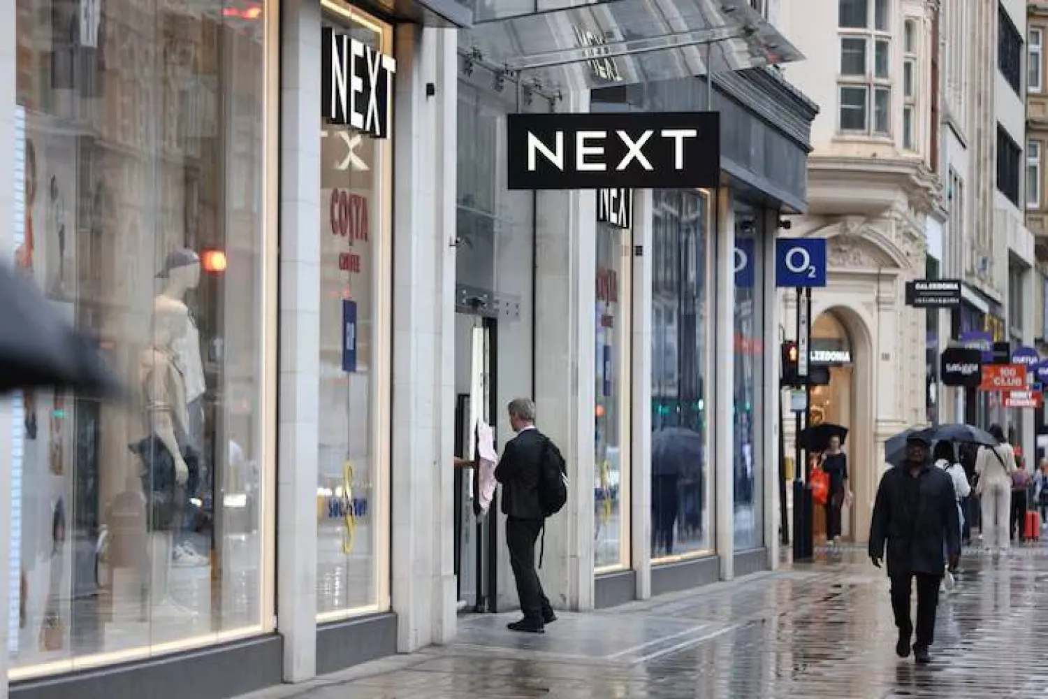 A shopper enters a Next store on Oxford Street in London, Britain, July 31, 2023. REUTERS/Hollie Adams/ File Photo