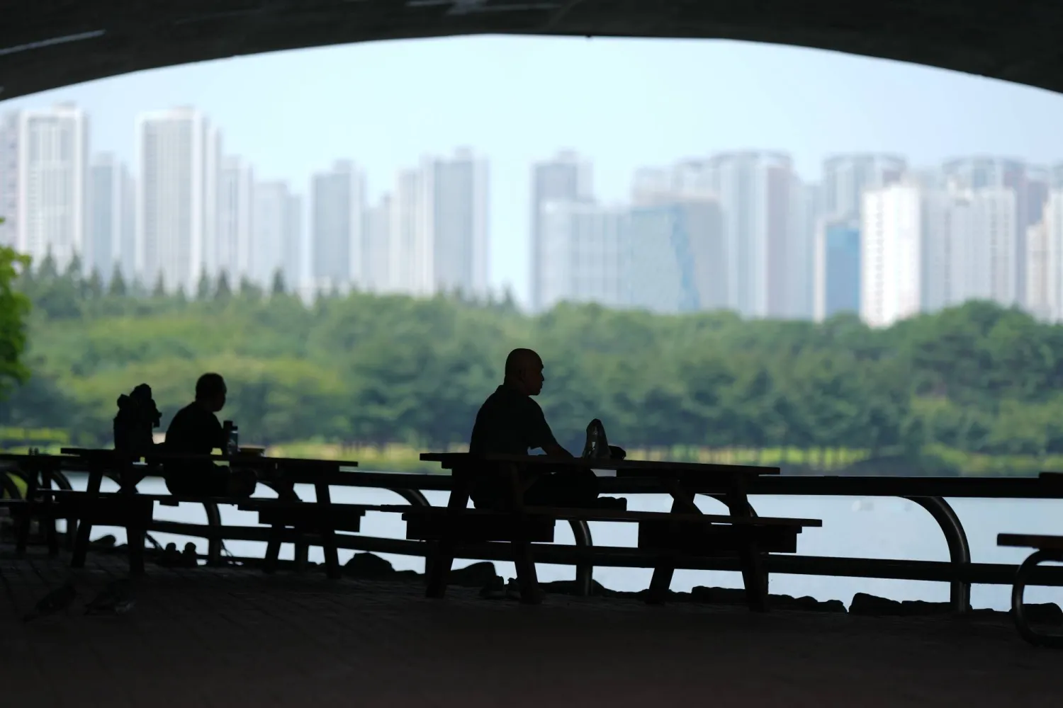 People sit in the shade to avoid the heat in Goyang, South Korea, Wednesday, Aug. 5, 2026. (AP Photo/Lee Jin-man)