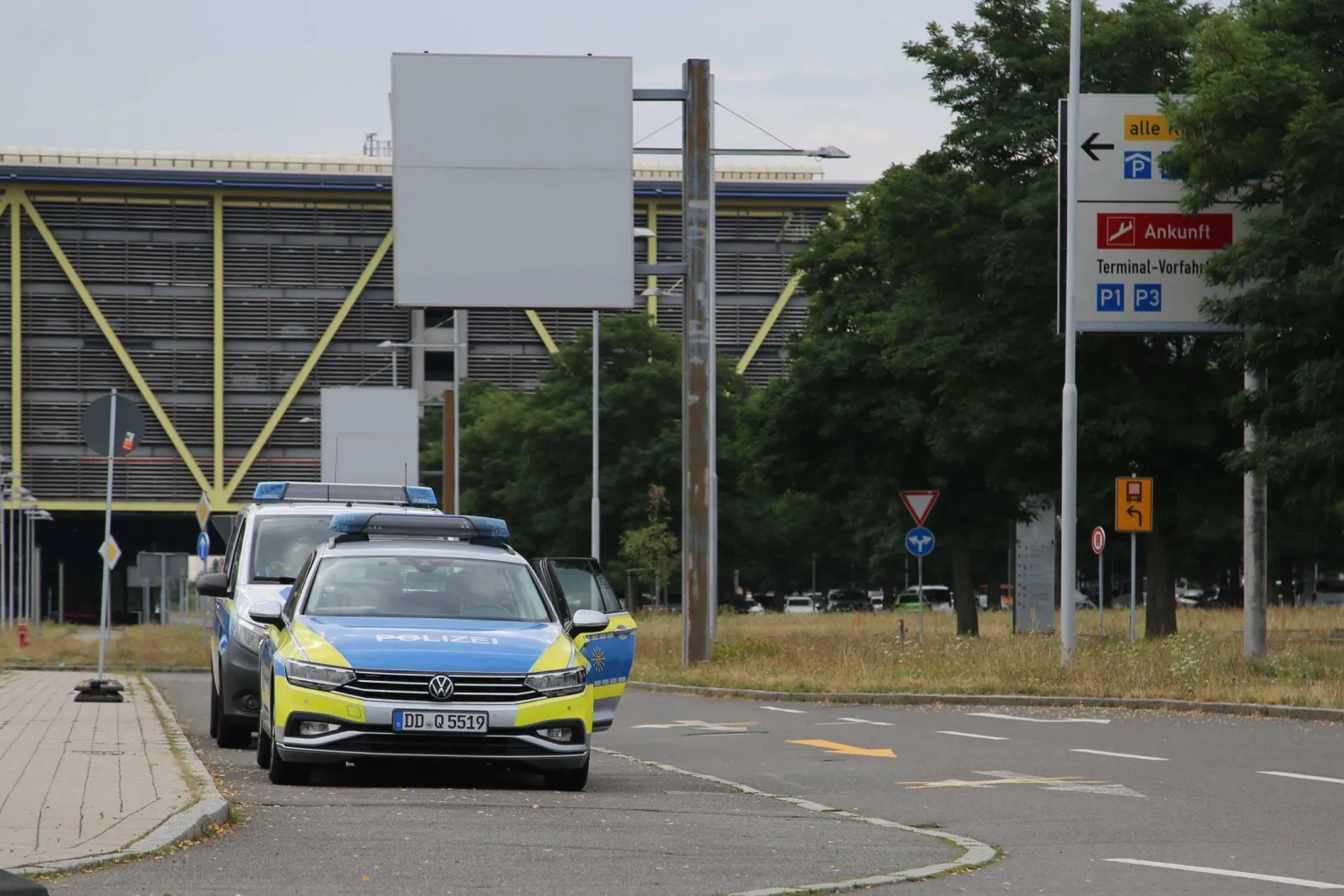 05 August 2026, Saxony, Schkeuditz: Police vehicles are parked in front of the airport administration entrance at Leipzig/Halle Airport. Photo: Tobias Junghanns/dpa