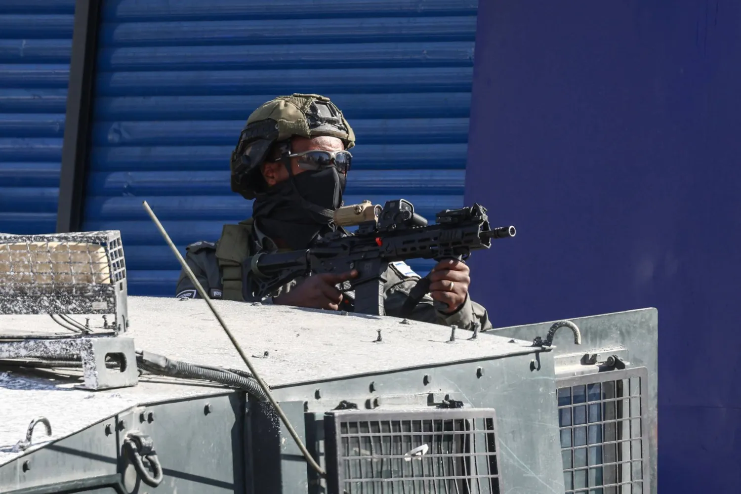 A member of the Israeli security forces holds a position during a military raid in the Qalandia refugee camp, south of Ramallah in the Israeli-occupied West Bank, on August 5, 2026. (AFP) 