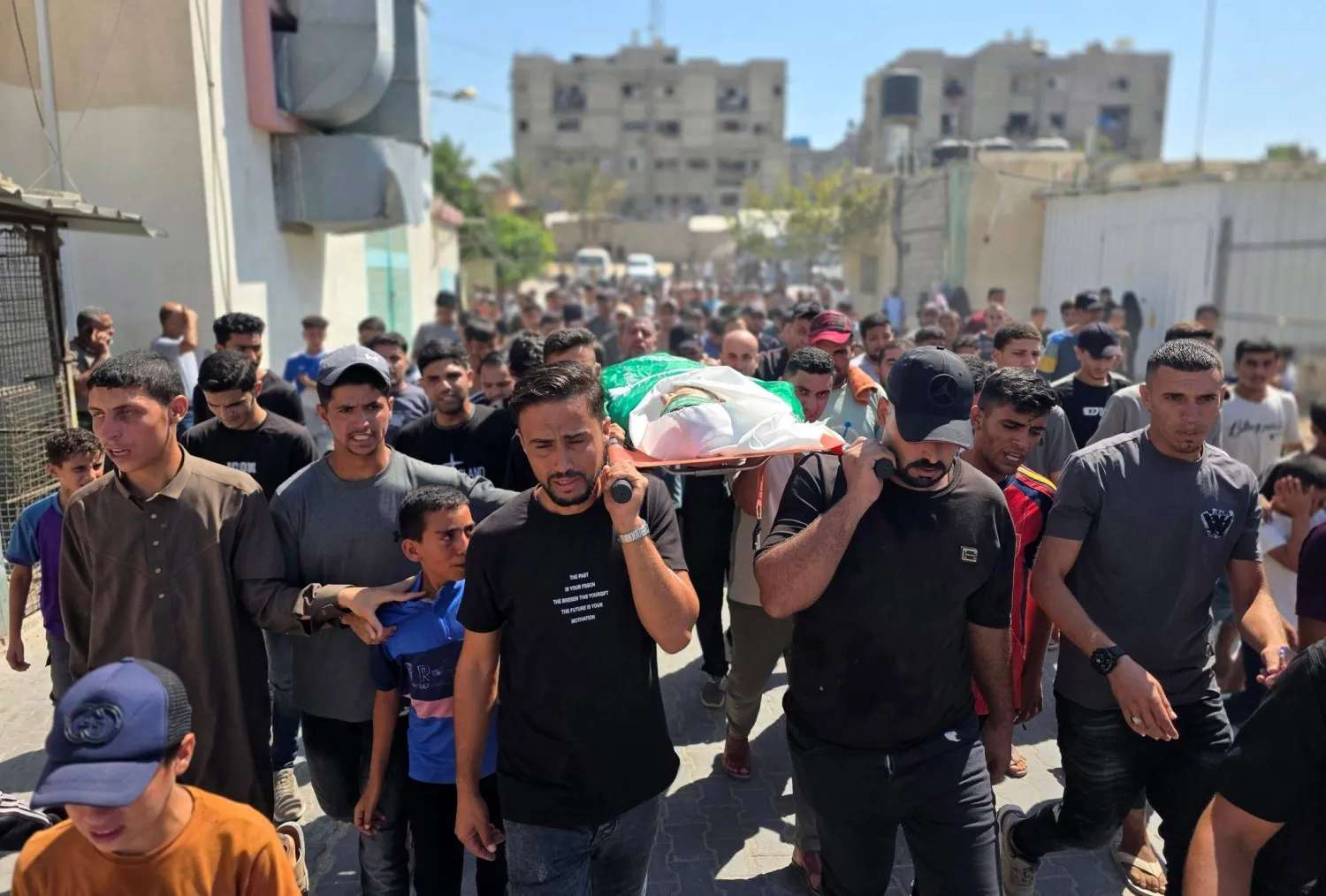 مشيعون يحملون جثمانَ فلسطيني تُوفي يوم الخميس متأثراً بإصابته في ضربة إسرائيلية استهدفت مخيم خان يونس بجنوب قطاع غزة (د.ب.أ)
