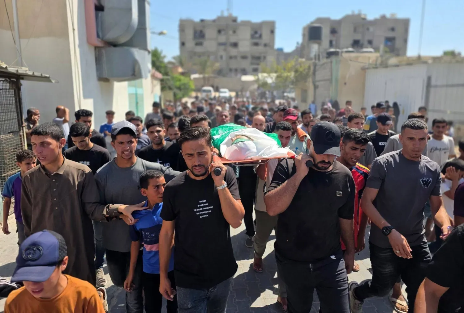 Cenaze törenine katılan Filistinliler, İsrail'in Gazze Şeridi'nin güneyindeki Han Yunus Mülteci Kampı'nı hedef alan saldırısında yaralandıktan sonra perşembe günü yaşamını yitiren bir Filistinlinin naaşını taşıyor. (DPA)